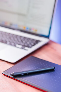 Graphic designer's workplace. Laptop and graphics tablet on a wooden table. Freelance work concept