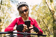 © ADDICTIVE STOCK - Bicyclist on bike browsing on smartphone in forest