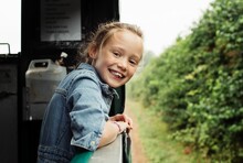 Portrait Of A Young Girl Happily Riding A Tractor