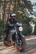 © perfectlab - Young male biker in a helmet travels on a motorcycle alone, on a road in the forest