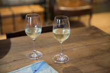 Two Glasses Of White Wine On A Wood Table