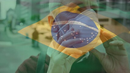 Poster - Animation of flag of brazil waving over caucasian man wearing face mask in city street