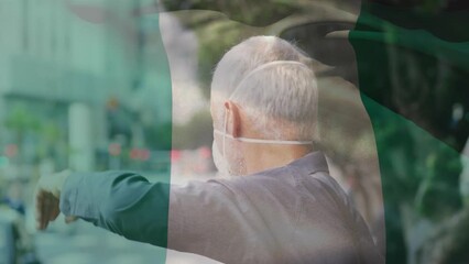 Sticker - Animation of flag of nigeria waving over caucasian man wearing face mask in city street