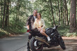 © perfectlab - Young beautiful couple hugging, sitting on a motorcycle, travel together on a forest road