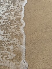 Soft sea wave on the beach, sand background
