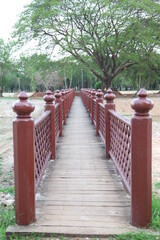  Wooden red bridge. Cross a pond to the temple in Sukhothai Historical Park, Thailand