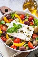 Wall Mural - Classic Greek salad of fresh cucumber, tomato, sweet pepper, lettuce, red onion, feta cheese and olives with olive oil.