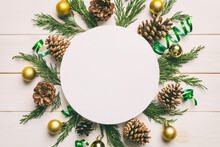 Flat Lay Christmas Composition. Round Paper Blank, Pine Tree Branches, Christmas Decorations On Colored Background. Top View, Copy Space For Text