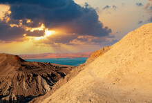 Sunset On A Large Salt Formation Mountains Range Sodom With Fluffy Clouds. Sun Shining On Rocky Hills Sodom Landscape. Dead Sea In Israel. Evening Gold Sunset Sky Over Mountains Sodom And Gomorrah