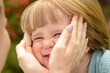 Portrait of a little boy, close-up. face of a child in mother's hands. Women's hands painfully stroking her son's face. Concept: maternal care, maternal love, tenderness, affection, maternal instinct,