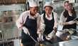 Chef in the kitchen provides cooking training to students.Schoolgirls happily cook together.children wearing cooking uniform.
