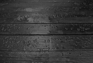  Pattern of drops and puddles of water on old vintage boards black and white texture background 
