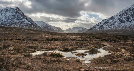 Wall Mural - Majestic dramatic Winter sunset sunbeams over landscape of Lost Valley in Etive Mor in Scottish Highlands