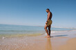 © RABBPodructions - MEN WALKING ON THE BEACH ON HIS SUNNY VACATION