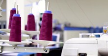 Purple Spool Of Sewing Threads Unrolling On Sewing Machine