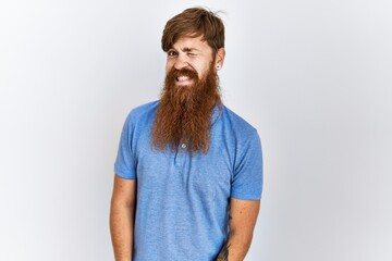 Canvas Print - Caucasian man with long bear standing over isolated background winking looking at the camera with sexy expression, cheerful and happy face.