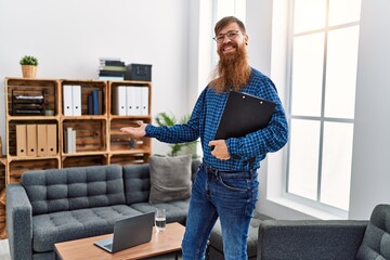 Sticker - Young redhead man psychology holding clipboard standing at clinic