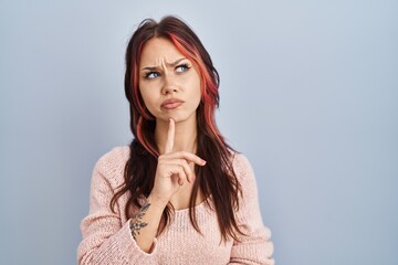 Canvas Print - Young caucasian woman wearing pink sweater over isolated background thinking concentrated about doubt with finger on chin and looking up wondering