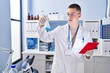 © Krakenimages.com - Young hispanic man scientist measuring liquid using touchpad at laboratory