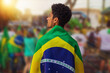Leinwandbild Motiv Brazil's Independence Day - Handsome Black Young Man Holding Brazil Flag on Cinematic Background