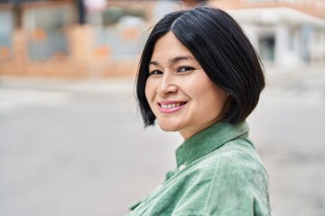 Wall Mural - Young chinese woman smiling confident standing at street