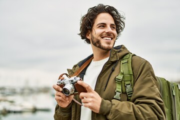 Poster - Handsome hispanic man using vintage camera by marina port