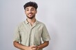 © Krakenimages.com - Arab man with beard standing over white background with hands together and crossed fingers smiling relaxed and cheerful. success and optimistic
