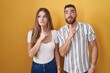 © Krakenimages.com - Young couple standing over yellow background thinking concentrated about doubt with finger on chin and looking up wondering