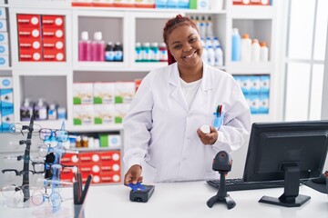 Sticker - African american woman pharmacist using credit card and data phone at pharmacy