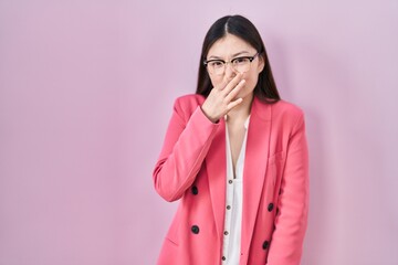 Poster - Chinese business young woman wearing glasses smelling something stinky and disgusting, intolerable smell, holding breath with fingers on nose. bad smell