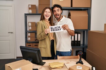 Canvas Print - Young two people holding black friday banner at small business store celebrating crazy and amazed for success with open eyes screaming excited.