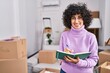 © Krakenimages.com - Young middle east woman smiling confident writing on notebook at new home