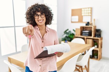 Poster - Young middle eastern woman wearing business style at office pointing to you and the camera with fingers, smiling positive and cheerful