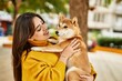 © Krakenimages.com - Beautiful young woman hugging happy shiba inu dog at park