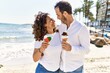 © Krakenimages.com - Middle age hispanic couple hugging and eating ice cream at the beach.