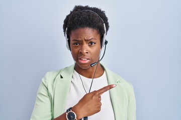 Poster - African american woman wearing call center agent headset pointing aside worried and nervous with forefinger, concerned and surprised expression