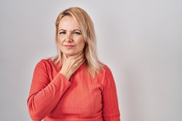 Canvas Print - Blonde woman standing over isolated background touching painful neck, sore throat for flu, clod and infection