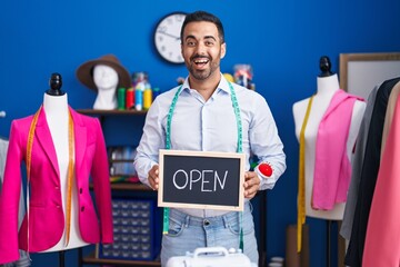 Poster - Hispanic man with beard working as dressmaker at atelier smiling and laughing hard out loud because funny crazy joke.