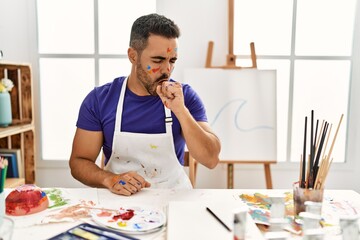 Wall Mural - Young hispanic man with beard at art studio with painted face feeling unwell and coughing as symptom for cold or bronchitis. health care concept.