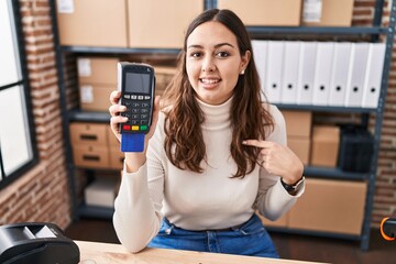 Sticker - Young hispanic woman working at small business ecommerce holding dataphone pointing finger to one self smiling happy and proud