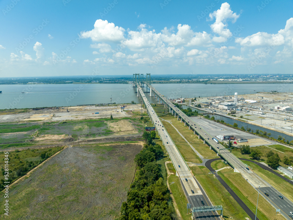 Aerial view of the Delaware Memorial Bridge spanning across the Delaware river connecting to the New Jersey turnpike with a giant chemical plan in the background