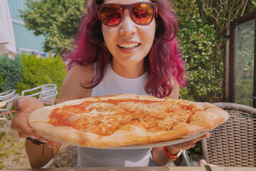 Wall Mural - Happy woman eating delicious margarita freshly baked and hot pizza in pizzeria. Cafe and restaurant serving authentic italian cuisine