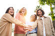 © CarlosBarquero - Group of young entrepreneur team stacking hands outdoors and looking at the camera