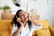 © CarlosBarquero - Motivated young woman listening to music with digital tablet while sitting on sofa at home.
