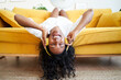 © CarlosBarquero - Motivated young woman singing and listening music with earphones while resting on sofa at home.