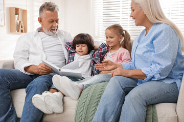 Wall Mural - Happy grandparents spending time with grandchildren at home