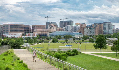 Woman walking on paved walking path with skyline of Arlington in the background - Arlington, Virginia, USA