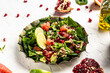 Vegan winter salad by chef hand in home kitchen with quinoa, spinach, avocado, grapefruit, pomegranate, nuts and microgreens