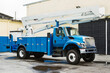 Front and side view of parked power utility truck.