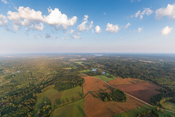 Wall Mural - Aerial view of fields, forests and lake on a sunny summer morning, Latvia.